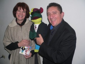 Theresa presents pastor Moises with the puppet that she has created for his children's ministry and radio show personality "Super Sapo"