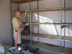 Placing shelving into the "bodega" (the storage room) at the Casa del Obrero