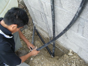 Javier hooks up the water lines for the storage tank