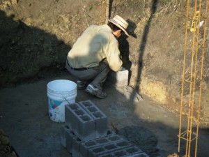 Javier laying block at the newly constructed Casa del Obrero septic tank