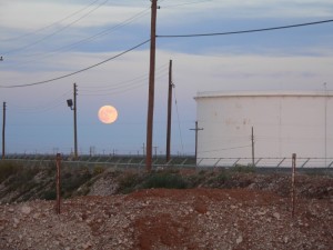 Moon rise against the bulk tank, cleachy pad, and power lines. Beauty is in the eyes of the beholder