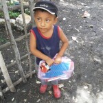 A happy little boy receives kindergarten supplies.