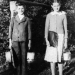 My mother, Lydian and her little brother Amos on their way to school. Notice the honey pails that were thier lunch buckets for school. Mom’s seems a tad beat up. Maybe she was beating on too many of the boys with it?